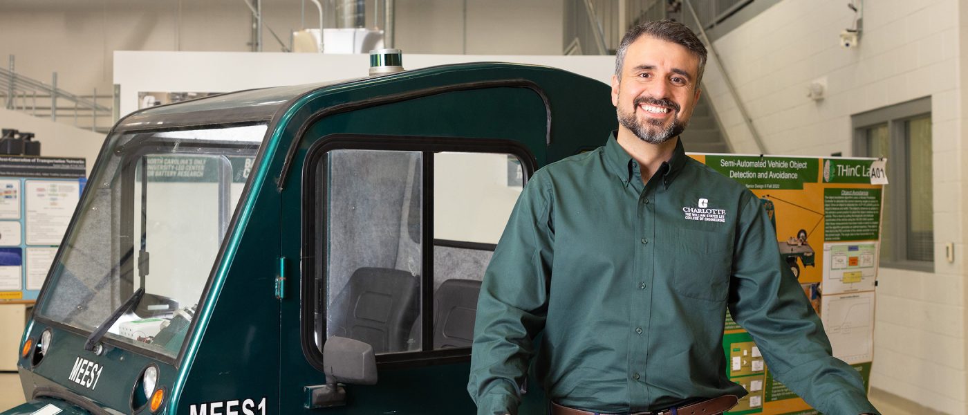 Amir Ghesami standing in front of autonomous vehicle in the BATT CAVE research center